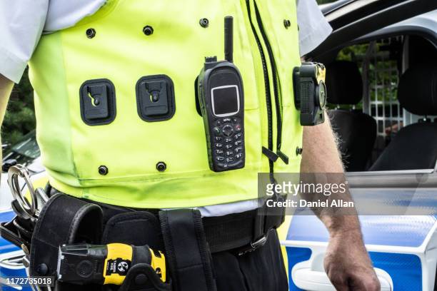 police radio and stun gun and waist cost jacket  close-up - police taser - fotografias e filmes do acervo