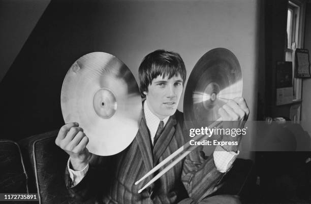 English drummer Mick Avory of rock band The Kinks holding drum cymbals and sticks, UK, 21st May 1965.