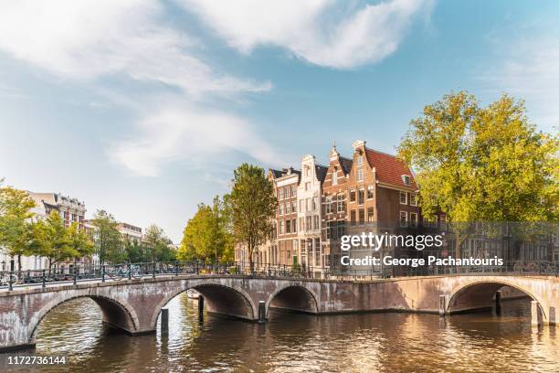 amsterdam bridge and houses - estrecho fotografías e imágenes de stock