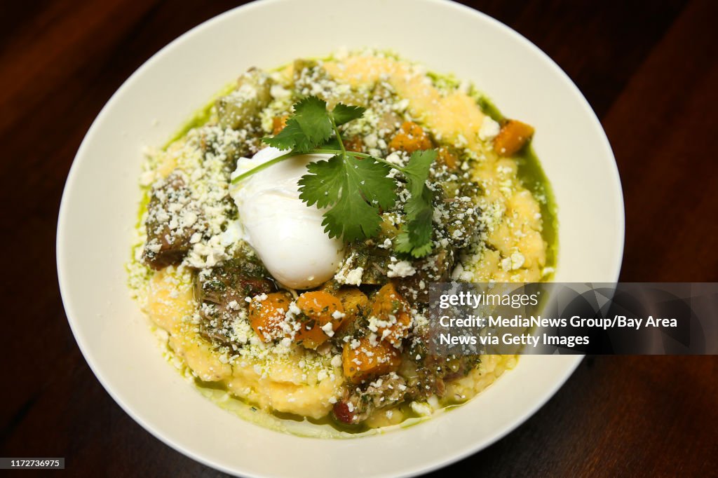 Braised pork shoulder is photographed at Cafe Eugene on Wednesday, Feb. 24, 2016, in Albany, Calif. The dish includes cotja cheese, tomatillos, chayote, acorn squash, wild herb sauce, creamy grits and is topped with a poached egg. (Aric Crabb/Bay Area N