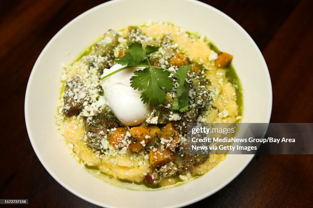 Braised pork shoulder is photographed at Cafe Eugene on Wednesday, Feb. 24, 2016, in Albany, Calif. The dish includes cotja cheese, tomatillos, chayote, acorn squash, wild herb sauce, creamy grits and is topped with a poached egg. (Aric Crabb/Bay Area N