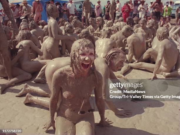 Black Rock Desert,Nevada,USA.September 2 4--BURNING MAN-- A young lady laughs as she rolled and danced in the mud after a desert thundershower.