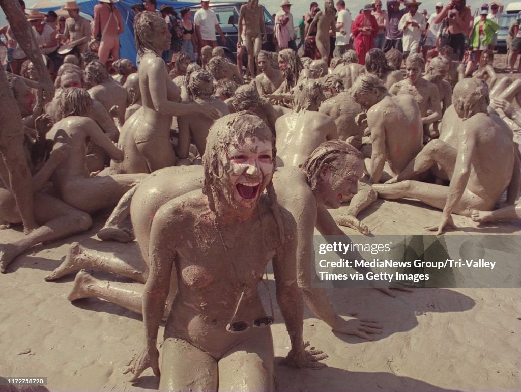 Black Rock Desert,Nevada,USA.September 2,3,4--BURNING MAN-- A young lady laughs as she rolled and danced in the mud after a desert thundershower. (Tomas Ovalle/Valley Times/Bay Area News Group)