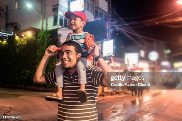 father and son on city at night - kids fun indonesia stock pictures, royalty-free photos & images
