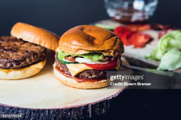 homemade cheeseburgers with ingredients in the background - burger on grill photos et images de collection