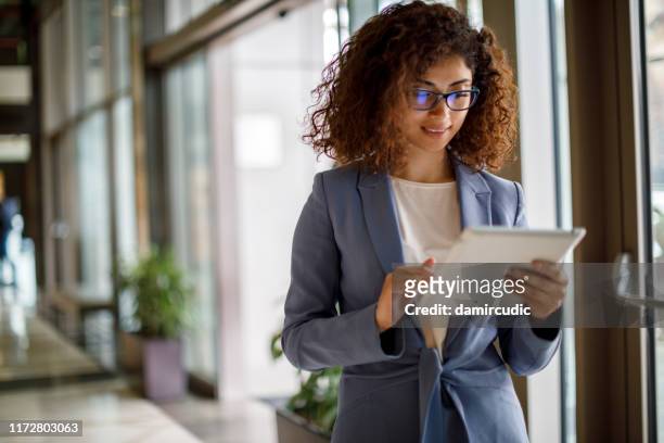 giovane imprenditrice che usa tablet digitale all'interno - usare un tablet foto e immagini stock