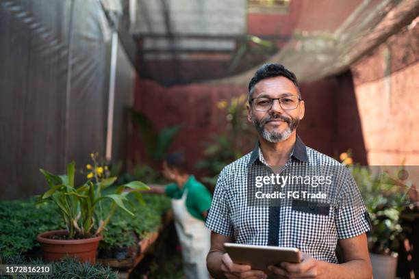 porträt des floristen mit tablet im small business flower shop - einzelhandel portrait stock-fotos und bilder