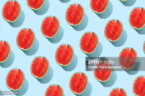 repeated watermelon on the blue background - wassermelone stock-fotos und bilder