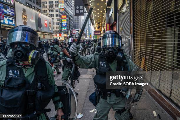 Riot police officer use his baton to chase journalist away while they attempt to arrest protesters. Entering the 18th week of civil unrest,...