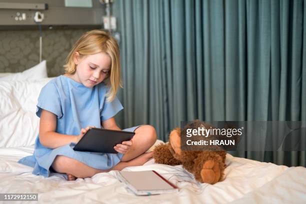 sick girl using digital tablet on hospital bed - children's hospital stock pictures, royalty-free photos & images
