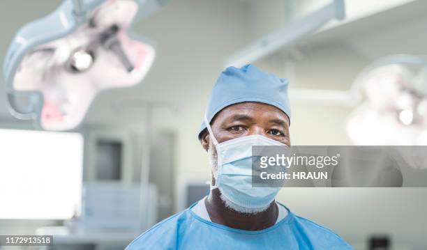 portrait of surgeon wearing protective wear - surgical mask man stock pictures, royalty-free photos & images