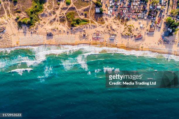 luft-drohnenansicht eines überfüllten strandschirms bars und menschen auf dem sommersand - bulgaria stock-fotos und bilder