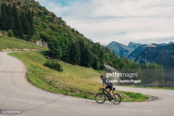 cyclist on hairpin bend on col de corbier - uphill stockfoto's en -beelden