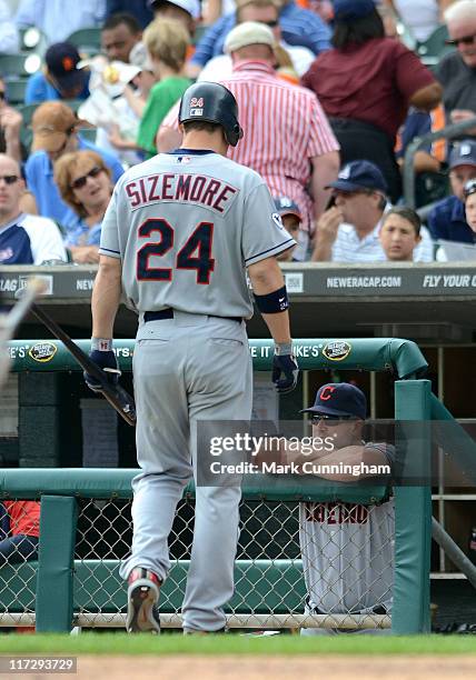 Grady Sizemore of the Cleveland Indians walks back to the dugout after striking out while manager Manny Acta looks on during the game against the...