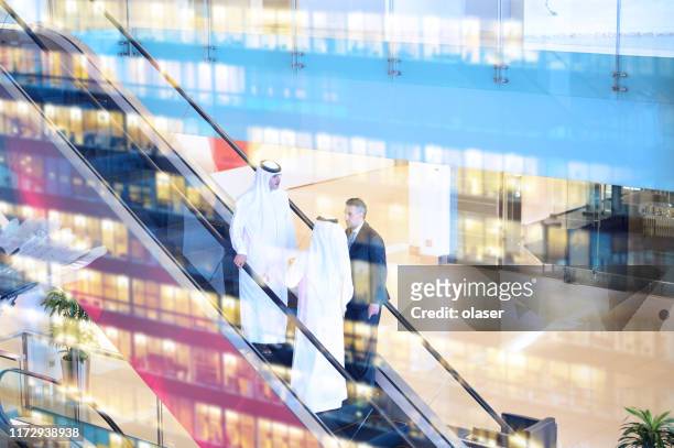 three arab business men entering building - arab businessman stock pictures, royalty-free photos & images