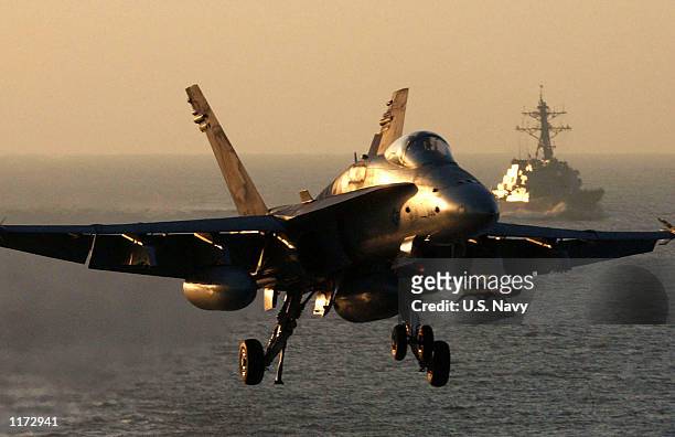 An F/A-18 "Hornet" approaches the flight deck of the USS Theodore Roosevelt October 30, 2001 as the USS McFaul trails behind as plane guard. The...
