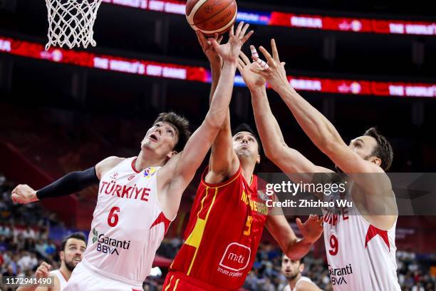 Milko Bjelica of Montenegro competes for the ball with Cedi Osman and Semih Erden of Turkey during the classification round of 2019 FIBA World Cup...