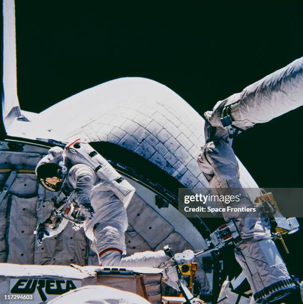 Member of the crew of Space Shuttle Atlantis looking over the European Space Agency's European Retrievable Carrier satellite in the aft cargo bay,...