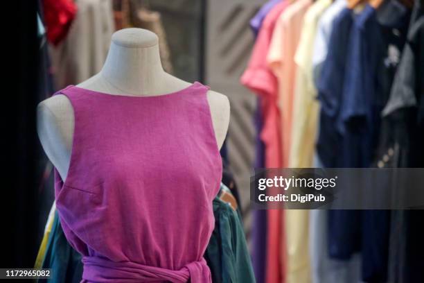 female like torso in pink casual dress against clothes hanging - sleeveless dress ストックフォトと画像