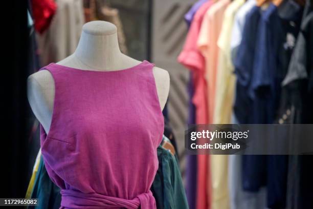 female like torso in pink casual dress against clothes hanging - damkläder bildbanksfoton och bilder