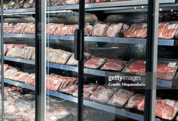 different types of packed meat at the refrigerated section of a supermarket - meat packaging imagens e fotografias de stock