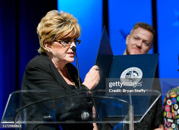 Las Vegas Mayor Carolyn Goodman presents Imagine Dragons a ceremonial proclamation as frontman Dan Reynolds of Imagine Dragons listens during Imagine...