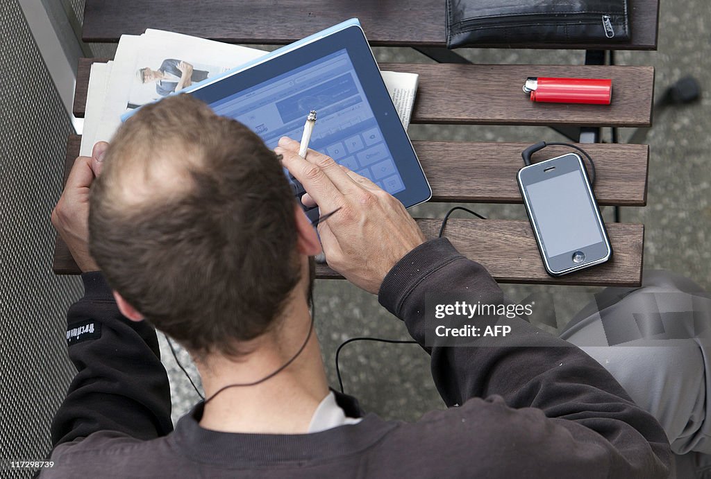 A man sitting  on a balcony surfs the we