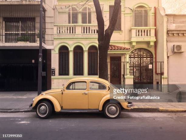 gele vintage auto geparkeerd in de straat - beetle car stockfoto's en -beelden