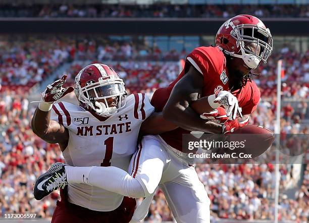 Jerry Jeudy of the Alabama Crimson Tide fails to pull in this reception as he is defended by Ray Buford Jr. #1 of the New Mexico State Aggies at...