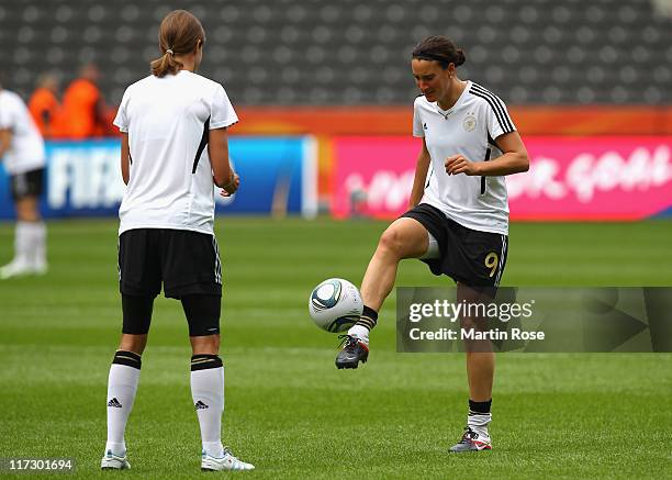 Birgit Prinz of Germany play the ball to KErstin Garefrekes during the Germany Women national team training session at Olympic stadium on June 25,...