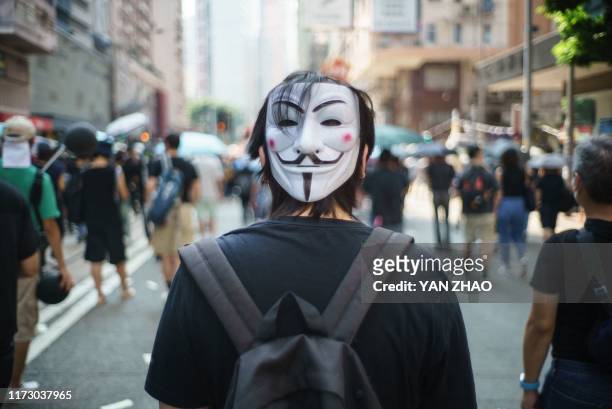 In this picture taken on October 1 a protester wears a Guy Fawkes mask on the back of his head, popularised by the V For Vendetta comic book film, in...