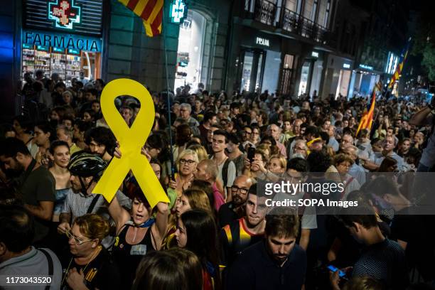 Protester holds a yellow ribbon during the demonstration. Convened by the sovereign entity Assemble Nacional Catalana about 20,000 people have come...