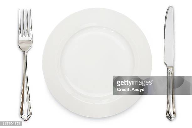 a white plate, knife and fork against a white background - tafelmes stockfoto's en -beelden