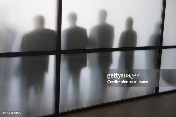 October 2019, Saxony, Dresden: During a break in the session, CDU members of parliament stand behind a glass pane in a conference room and stand out...