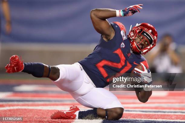 Runningback J.J. Taylor of the Arizona Wildcats scores on a 25 yard rushing touchdown against the Northern Arizona Lumberjacks during the first half...