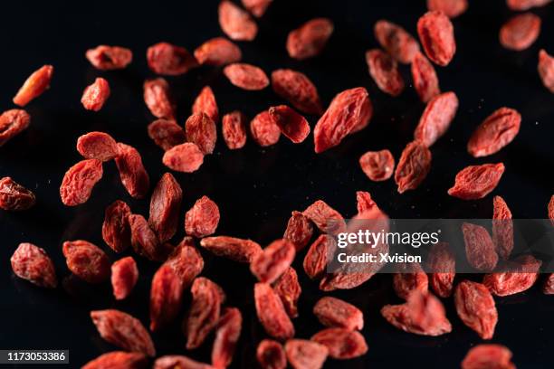 chinese wolfberry flying in mid air captured with high speed sync. - goji berry stock pictures, royalty-free photos & images