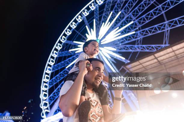 father and son ferris wheel at night - kids fun indonesia stock pictures, royalty-free photos & images