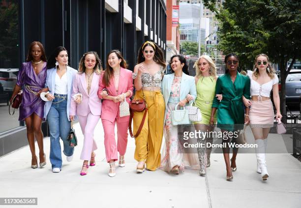 Guests wearing vibrant outfits walk together during New York Fashion Week at Spring Studios on September 07, 2019 in New York City.