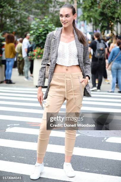 Guest wearing a blazer, white shirt, beige pants and white shoes during New York Fashion Week at Gotham Hall on September 07, 2019 in New York City.