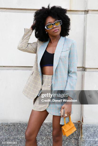 Guest is wearing a suit with a handbag during New York Fashion Week at Spring Studios on September 07, 2019 in New York City.