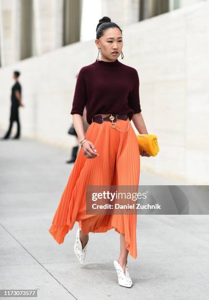 Jaime Xie is seen wearing a maroon sweater and orange skirt outside the Longchamp show during New York Fashion Week S/S20 on September 07, 2019 in...