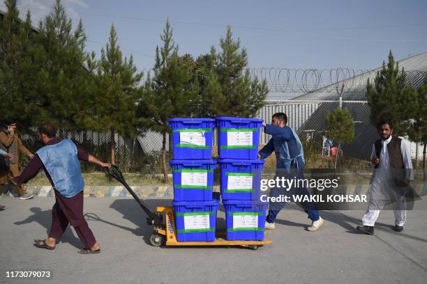 Independent Election Commission workers carry ballot boxes to be taken to a counting centre at the Data Centre in Kabul on October 2, 2019. - Voter...