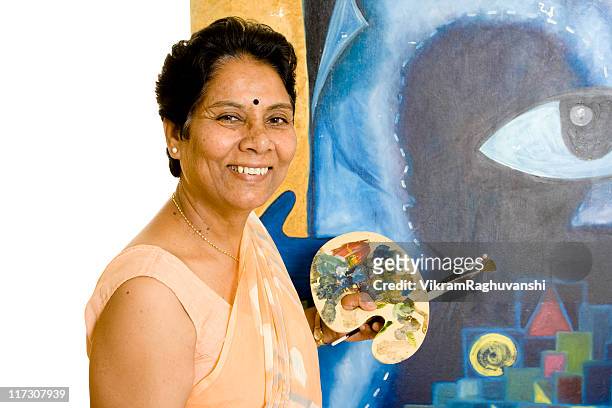 one indian senior woman artist working on her painting - indian painting stockfoto's en -beelden