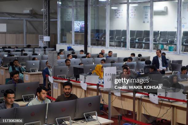 Independent Election Commission workers sit at a computer terminal while election information from all over the country is gathered at the Data...