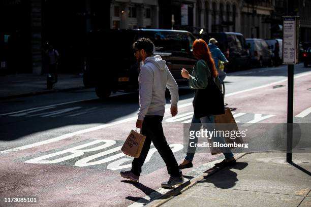 Pedestrians carry a Bloomingdale's Inc. And Zara shopping bag while crossing a street in New York, U.S., on Wednesday, Sept. 25, 2019. Bloomberg is...