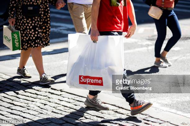 Pedestrians carry Supreme and American Eagle Outfitters Inc. Aerie brand shopping bags while walking along a street in New York, U.S., on Wednesday,...