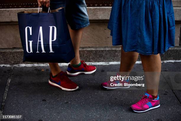 Pedestrian carries a Gap Inc. Shopping bag in New York, U.S., on Wednesday, Sept. 25, 2019. Bloomberg is scheduled to release consumer comfort...