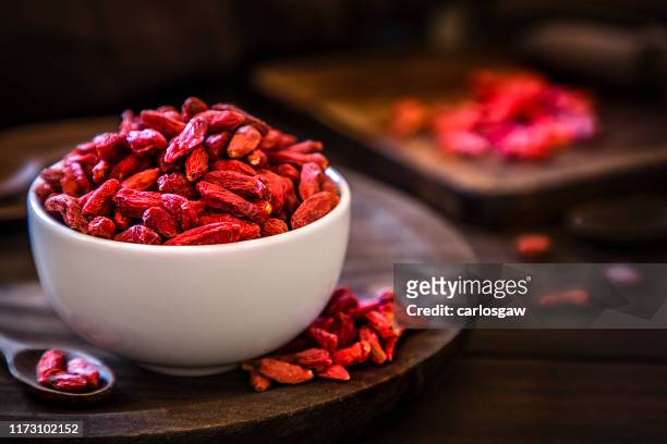 wolfberry bowl on rustic wooden table - goji berry stock pictures, royalty-free photos & images