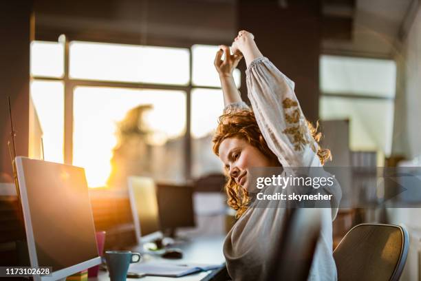 redhead computer programmer stretching in the office. - stretching stock pictures, royalty-free photos & images