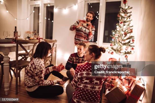friends exchanging christmas present at home - exchanging gifts stock pictures, royalty-free photos & images
